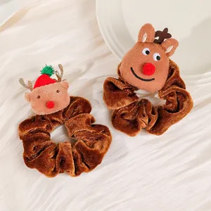 Detail view of two plush reindeer velvet scrunchies with cute Christmas themed designs