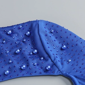 Macro shot of royal blue knit fabric with pearl beads and rhinestones detail