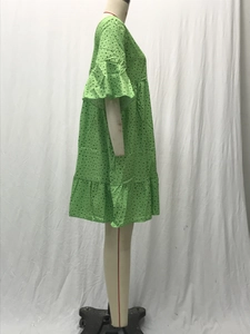 Detalle de vestido verde de lunares con falda de capas y diseño de manga con volantes