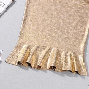 Detail of gold metallic mermaid dress showing ruffled hem and shimmering pleated fabric