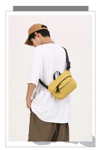 Detail of yellow nylon crossbody bag with adjustable black strap and durable zipper