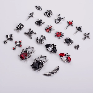 Macro view of silver Halloween nail charms with spiders, skulls and crosses