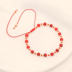 Handmade red stone beaded bracelet with golden spacers and bohemian braided cord
