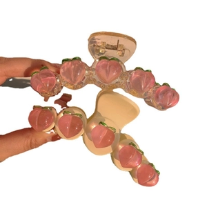 Pink heart-shaped hair claw clip with peach bear charms and sweet aesthetic style