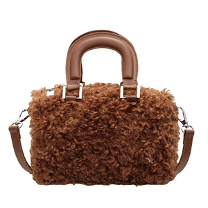 Brown fuzzy plush Boston bag with smooth top handles and silver hardware on white background