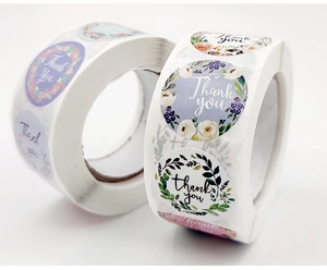 Detailed macro view of round floral thank you stickers roll for bakery packaging