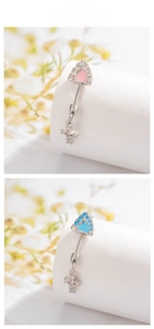 Detail of silver titanium steel navel rings with pink and blue heart cross pendants