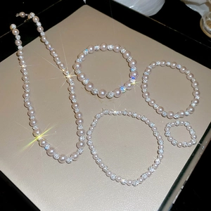 Detailed set of pearl and diamond-studded necklaces, bracelets and a ring on a tray