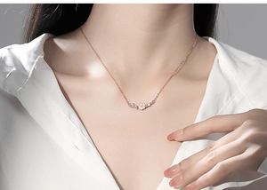 Close-up of S925 sterling silver necklace featuring rose gold flower and butterfly pendants