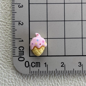 Macro shot of a mini pink resin ice cream charm showing 1.5cm size on a metric ruler