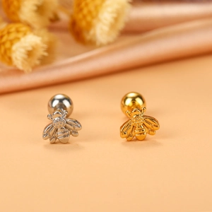Makroaufnahme von Bienen-Ohrsteckern in Gold und Silber mit Kugelverschluss-Details