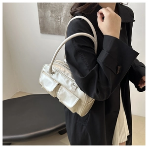 Close-up of beige PU leather shoulder bag featuring utility flap pockets and long handle