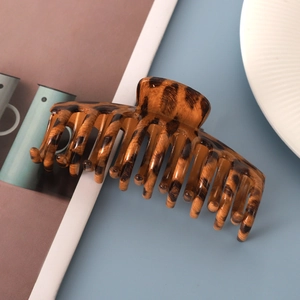 Macro view of a large leopard print claw clip for elegant hair styling and ponytail