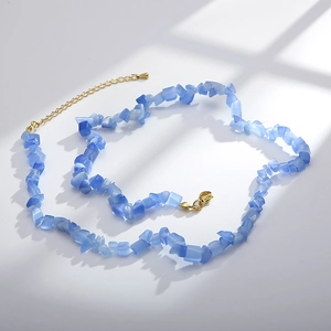 Detail showing blue irregular cat-eye stone necklace with gold-plated lobster clasp