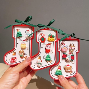 Handgehaltenes Display mit Weihnachts-Haarspangen-Sets mit Weihnachtsmann und Rentier