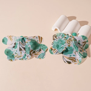Close-up of floral fabric earrings with white pearl centers on an artistic display