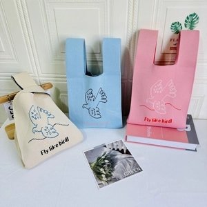 Detailed knit texture of tote bags with pixel bird patterns in pastel colors