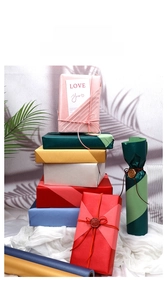 Detailed stack of large pearlescent gift wrapping paper in multiple vibrant solid colors