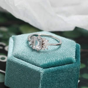 Macro shot of silver zircon ring with emerald cut center stone on velvet box
