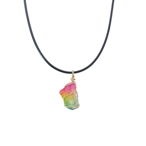 Detail of wire-wrapped irregular rainbow crystal pendant with gold wire and black cord