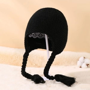 Close-up of black knitted baby hat with braids, earflaps and soft fleece lining