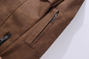Detailansicht der braunen Lederjacke mit Narbenstruktur und Metall-Reißverschlusstasche