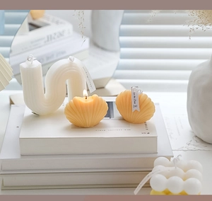 Detail shot of shell-shaped and wavy scented candles in a cozy minimalist interior