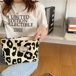 Detail of leopard print canvas tote bag with metal zipper and Pleasant Time woven label