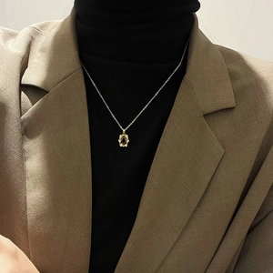Chic gold titanium necklace with oval black onyx pendant worn on professional outfit