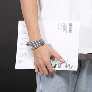 Detailed view of silver snake coil bracelet with scale texture on a fashion model