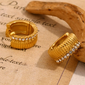 Macro view of 18K gold plated ridged earrings with white cubic zirconia inlay details