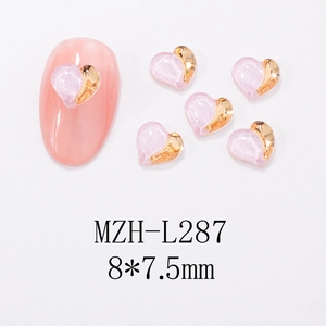 Macro view of two-tone heart nail charms on pink nail tip with 8x7.5mm dimensions