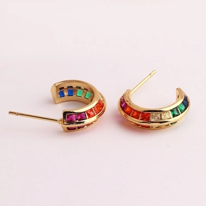 Detailed macro view of gold C-shaped earrings with micro-pave rainbow colored gemstones