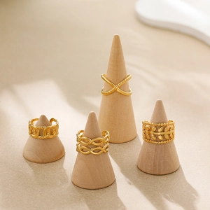 Detail of four 18K gold-plated titanium steel rings featuring leaf and twisted chain designs