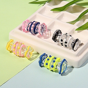 Macro shot of assorted colorful candy-shaped glass beads for DIY jewelry in a ceramic dish