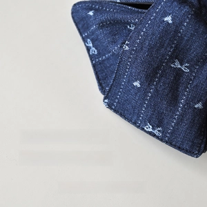 Détail macro du tissu denim délavé bleu avec motifs blancs et coutures soignées