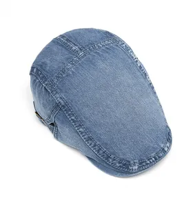 Detailed top view of washed denim flat cap showing cross-stitch seams and blue cotton fabric