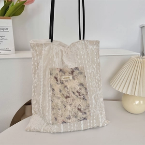 Detail of cream vintage tote bag showing retro floral patch and ribbed lace texture