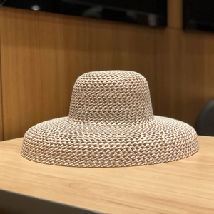 Détail de la texture fine au crochet d'un chapeau de paille beige à large bord pour femmes