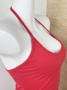 Detailed side view of a red backless halter knit vest on a white display mannequin