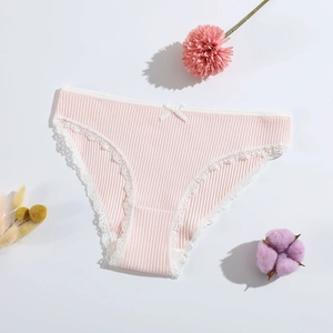 Pink ribbed cotton panties for women with lace trim and bow in a flat lay setup