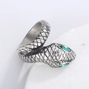 Macro view of silver snake ring with green crystal eyes and 316L stainless steel engraving