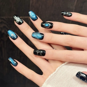 Faux ongles œil de chat bleu foncé avec constellations argentées et ornements