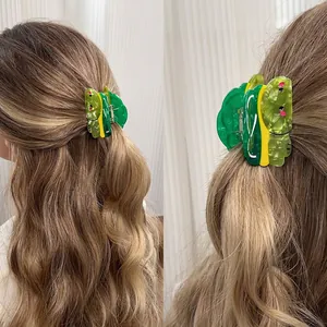 Green and yellow forest animal acetate hair claw clip shown in long hair and side view