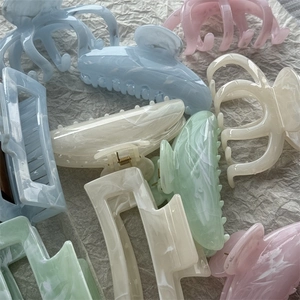 Pastel marble ink hair claw clips in blue pink cream and mint green on paper