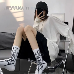 Détail de chaussettes mi-hautes blanches avec motif toile d'araignée noire style urbain