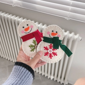 Detail of a handmade felt snowman Christmas ornament with red scarf and snowflake embroidery