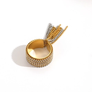 Detail of bicolor beaded stainless steel ring with elegant 18k gold tassel chains