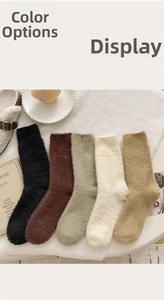 Close-up of five pairs of plush thermal socks in neutral colors on a cozy white rug