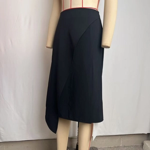 Detail view of high-waist black midi skirt with asymmetric cut and side slit design